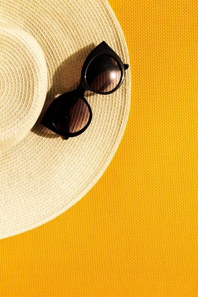 Krásný slaměný klobouk se slunečními brýlemi na žluté zářivé živé — Stock fotografie