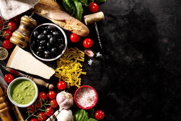 Saborosos ingredientes alimentares italianos apetitosos frescos em fundo escuro — Fotografia de Stock