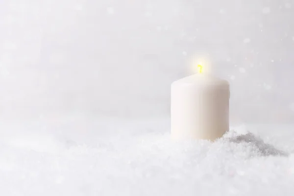 Burning candle in snow — Stock Photo, Image