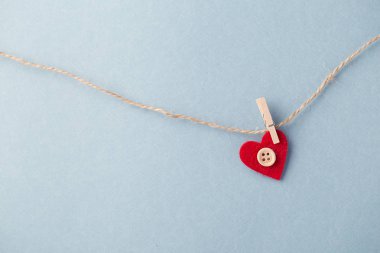 Küçük kalp mavi karşı asılı düğmesi ile