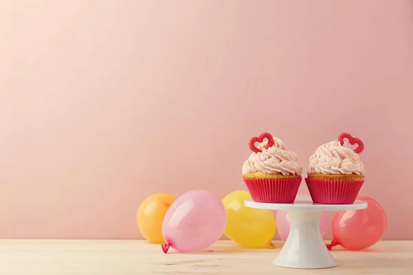 Doces cupcakes e balões em arranjo — Fotografia de Stock