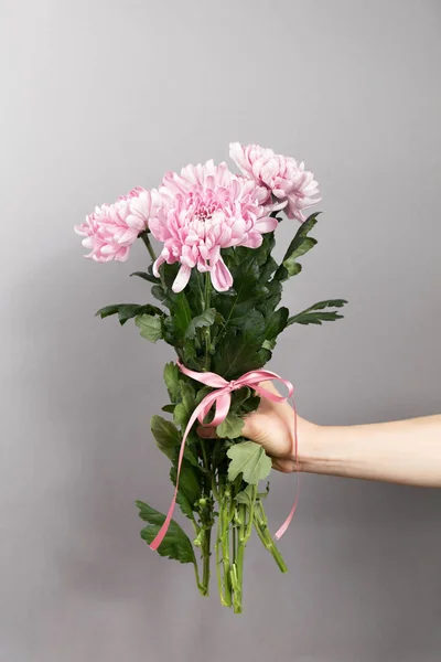 Hand der Person mit rosa Blumenstrauß — Stockfoto