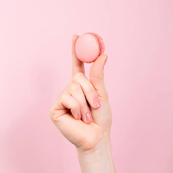 Mão segurando macaroon rosa — Fotografia de Stock