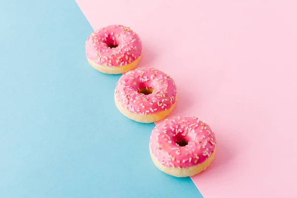 다 색 배경에 3 핑크 도넛 — 스톡 사진