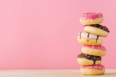 Pembe üzerinde farklı donuts yığını