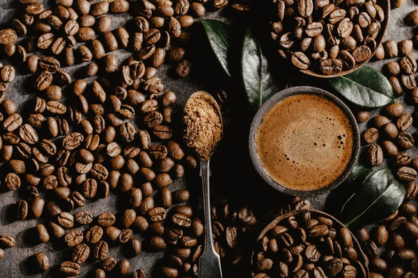 Gebrühter schwarzer Kaffee und Bohnen im Arrangement — Stockfoto