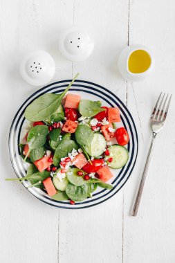 plaka karışık yeşillik ve sebze ve peynir ve nar tohumları ile tepesinde