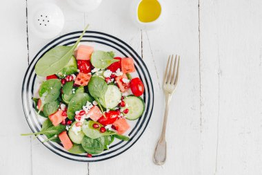 plaka karışık yeşillik ve sebze ve peynir ve nar tohumları ile tepesinde