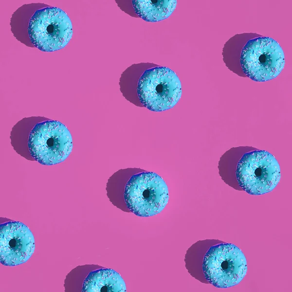 Плоская Укладка Повторяющихся Голубых Глазированных Пончиков Брызгами Ярко Розовом Фоне — стоковое фото