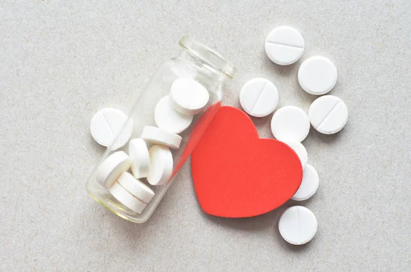 Az üvegben, piros szív fehér tabletta — Stock Fotó