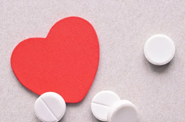 Fehér tabletták és piros szív — Stock Fotó