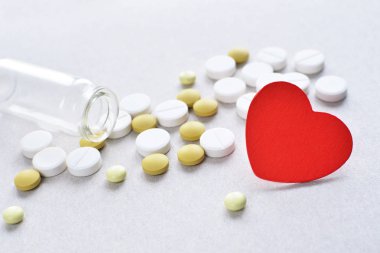 Tablet ile kırmızı kalp ve cam şişe