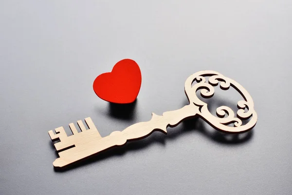 key and heart on grey background