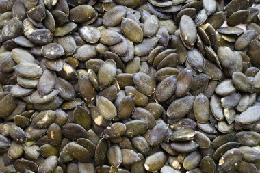 Taze koyu yeşil kabak çekirdeği Beyaz ahşap arka plan üzerinde dağınık