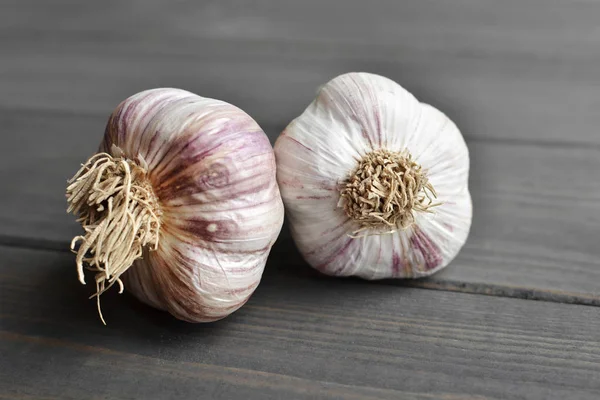 Dry fresh garlic bulbs on old dark wooden background — Stock Photo, Image