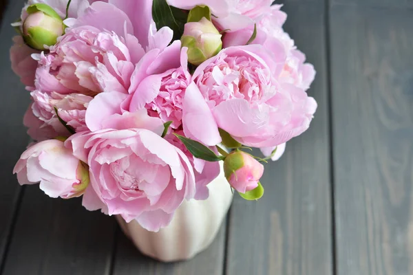 Blumenstrauß aus rosa Pfingstrosen in der Vase auf Holzgrund — Stockfoto