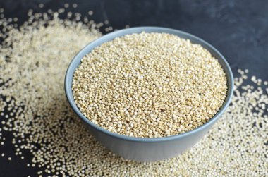 Ceramic bowl with white quinoa seeds, organic superfood for healthy eating