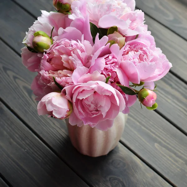 Ramo de flores de peonía rosa en jarrón sobre fondo de madera — Foto de Stock