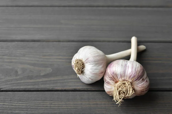 Dry fresh garlic bulbs on old dark wooden background, top view, copy space — Stock Photo, Image