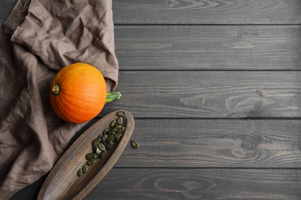 Semillas secas de calabaza verde austriaca orgánica con calabaza sobre fondo oscuro de madera. Comida saludable. Copiar espacio . — Foto de Stock