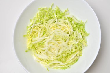 Beyaz masa arkasında kasede taze Çin lahana salatası. Vejetaryen yemek yaşam tarzı. Üst görünüm.