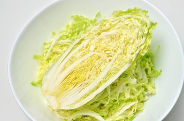 Beyaz arka planda Çin lahana salatası. Vejetaryen yemeği.