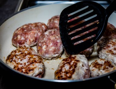 Pirzola. Fırının üstünde demir bir tavada kızarmış pirzola. Mutfakta pirzola pişirme işlemi..