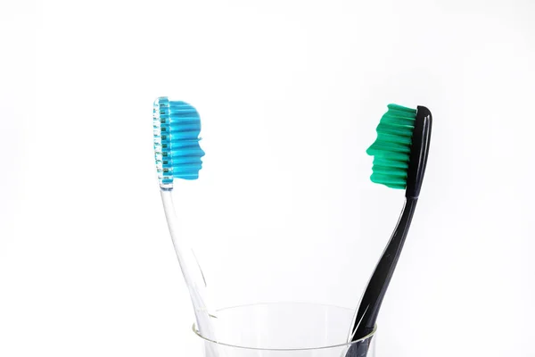 Escovas Dentes Cores Diferentes Copo Vidro Fundo Branco — Fotografia de Stock