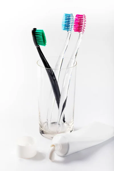 Sikat Gigi Dengan Warna Yang Berbeda Dalam Gelas Piala Kaca — Stok Foto