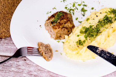 Beyaz tabakta patates püresi ve sığır pirzolası..