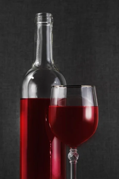 Flasche Und Glas Rotwein Auf Dem Tisch Vor Dunklem Hintergrund — Stockfoto