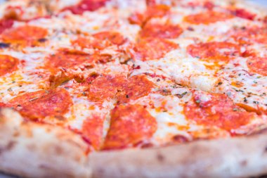 Delicious pepperoni pizza and basil tomato cooking ingredients. Top view of hot pepperoni pizza.