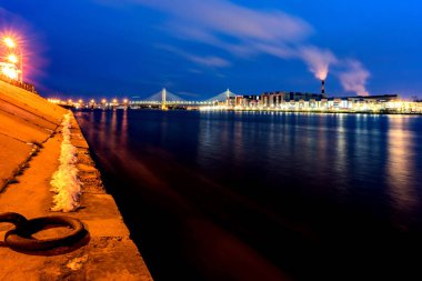 St. Petersburg 'daki Neva Nehri' nin gece seti. Neva Nehri 'ne bakan akşam manzarası ve Kablolu TV Köprüsü.