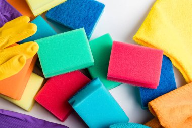 Beyaz arka planda bulaşık süngeri. Bir yığın sünger ve bez, beyaz arka planda bulaşık yıkamak için eldiven..