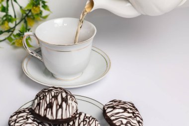 Masada, çikolatalı marşmelov, beyaz bardak ve çay için çaydanlık..