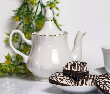 Masada, çikolatalı marşmelov, beyaz bardak ve çay için çaydanlık..