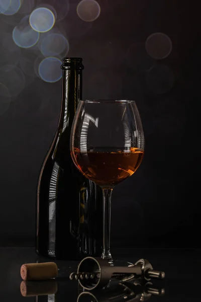 黒の背景にコルクとコルク栓付きのワインとガラスのボトル 美しいボケと反射 — ストック写真