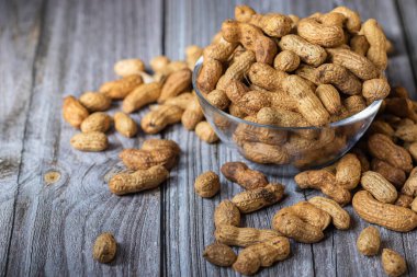 Sağlıklı çerezler fıstık desenli. Sağlıklı beslenme kavramı. Ahşap bir arka planda cam bir kasede yer fıstığı.