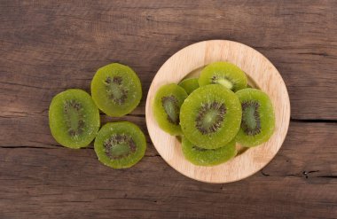 Ahşap arka plan üzerinde kurutulmuş kivi