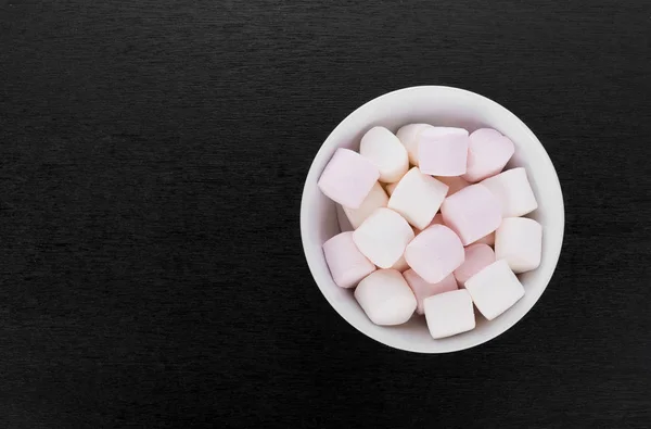 Marshmallows in a bowl on black wooden background — Stock Photo, Image