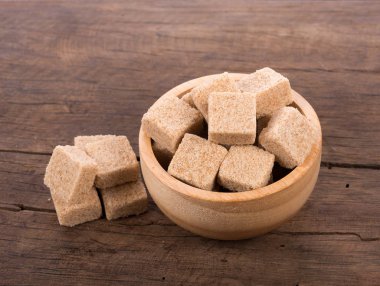 Ahşap arka plan üzerinde kahverengi şeker kamışı küpleri