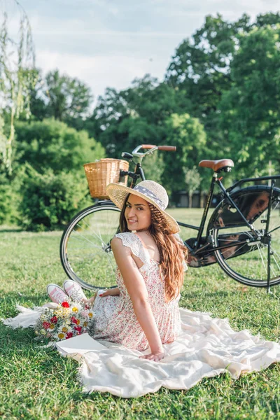 Woman sitting on picnic rug