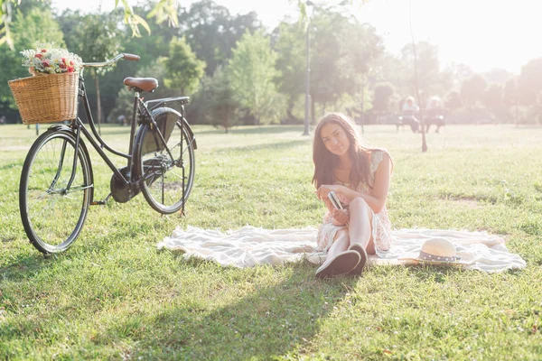 Woman sitting on picnic rug