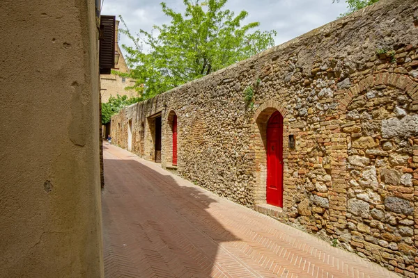 Starożytna Brukowana Ulica Średniowiecznej Miejscowości San Gimignano Toscana Czerwonymi Drzwiami — Zdjęcie stockowe