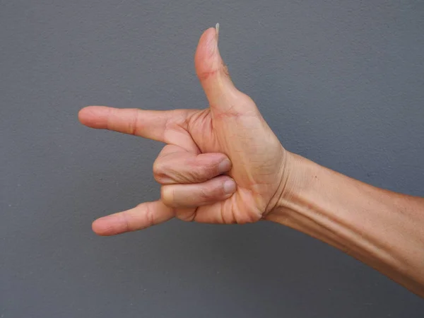 A hand making love sign on gray background — Stock Photo, Image