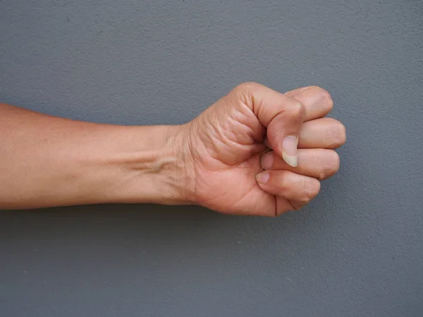 A hand making punching fist on gray background — Stock Photo, Image