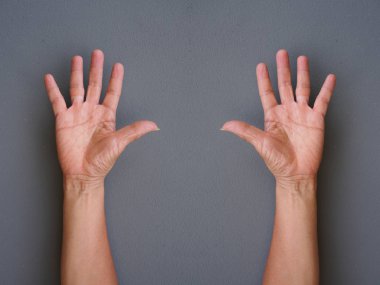 Ellerini yukarı kaldır gri arka plan üzerinde yapma eller