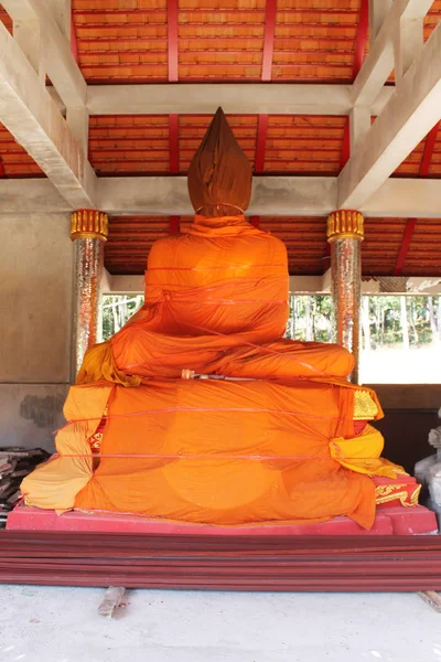 Estátua de buddha envolta por roupão amarelo — Fotografia de Stock