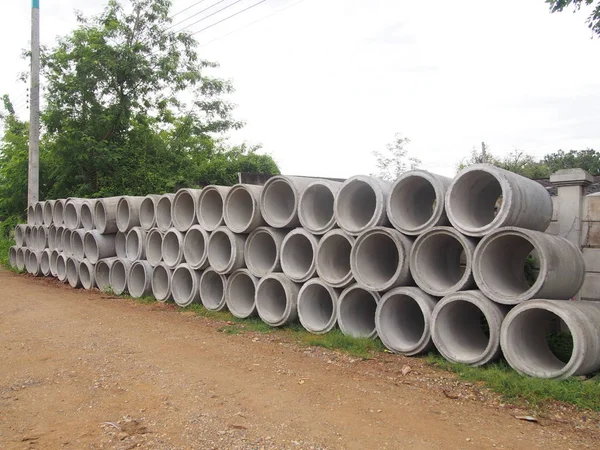 Montão de tubos de drenagem de concreto empilhados no canteiro de obras com perspectiva decrescente Fotos De Bancos De Imagens