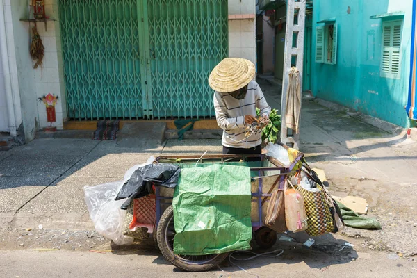 Um coletor de lixo coletando coisas não usadas em uma pequena rua, Saigon, Vietnã — Fotografia de Stock